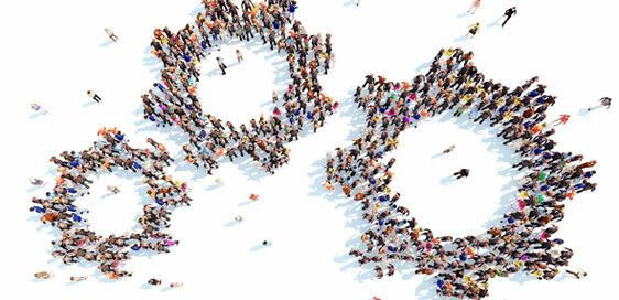 Photo of three cog-like shapes of different sizes, when you zoom in you see the cog is made of people