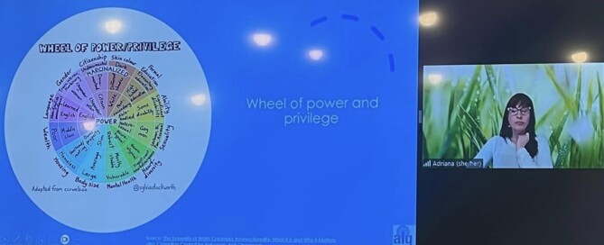 Screenshot of a woman giving a virtual presentation. The slide she is showing has text that says wheel of power and privilege with a graphic.