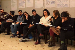 8 individuals sitting next to each other and taking notes, attending training on Sexual Harassment.